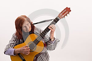 Funny elderly lady playing acoustic guitar