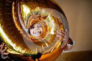 Funny emotional child girl with golden balloon