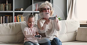 Funny excited two generations family gamers play video game at home