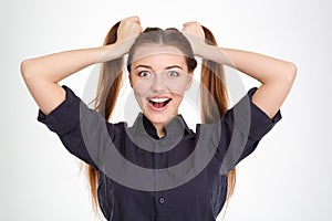 Funny excited young woman with two ponytails holded by hands