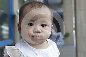 Funny face of asian baby in home living room