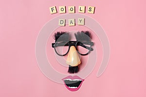Funny face - fake eyeglasses, nose and mustache on pink background