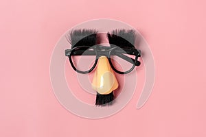 funny face - fake eyeglasses  nose and mustache on pink background Happy fools day concep