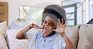 Funny, face and girl child with tongue out on a sofa for fun, playing or goofy personality at home. Crazy, hand gesture