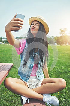 Funny face, girl and selfie on bench in park for profile picture on social media or memory of summer vacation in