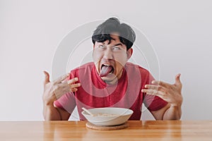 Funny face of man eat very hot and spicy instant noodle.