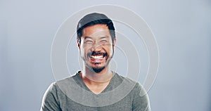 Funny, face and man laughing in a studio for comic or silly joke in conversation with happiness. Smile, portrait and