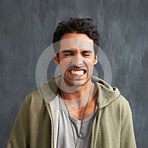 Funny, face and man in studio with crazy, gesture or facial expression against grey background. Joke, eyes closed and