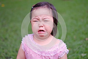 Funny face of a sad little girl crying and frowning