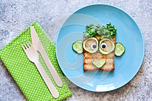 Funny faces - lunch for the child. Sandwich with vegetables. View from above