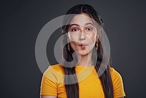 Funny faces are my thing. Cropped portrait of an attractive teenage girl standing alone and feeling playful against a