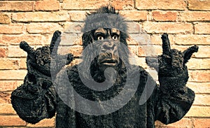 Funny fake gorilla with rock and roll hand gesture