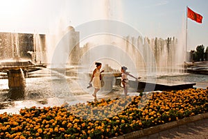 Funny family jump near the fountains on a hot day