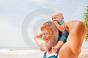 Funny family photo. Baby son sit on father shoulders.