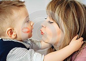 Funny family photo. The one-year-old son hugs his mother tightly and looks at each other. Close-up portrait. Cute happy
