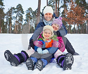 Funny family is sledging in winter-landscape