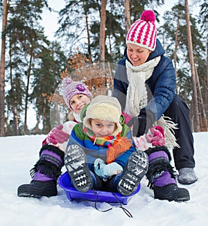 Funny family is sledging in winter-landscape