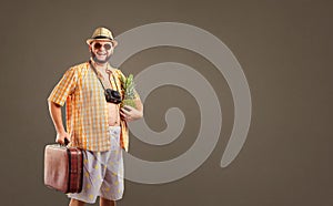 A funny fat bearded tourist with a pineapple and a suitcase smil