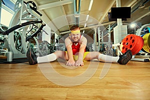 A funny fat man with a beard in the gym