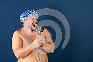 Funny fat man in blue cap sing in the shower