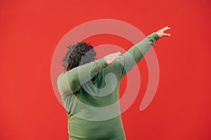 Funny fat man in casual clothes dancing dub dance on red wall background. Isolated. Close up