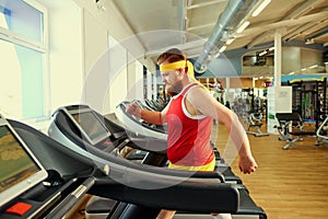 A funny fat man doing exercises in the gym.