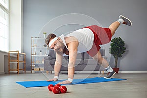 Funny fat man doing yoga exercises in the room.