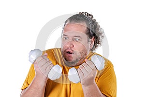 Funny fat man exercising with dumbbells and looking at camera isolated on white background