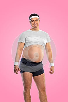 A funny fat man isolated on pink background. Obesity and eating disorder. Concept for dietetics and fitness advertising