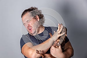 Funny fat man poses with little dog on gray background