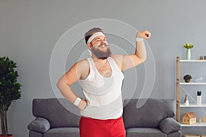 Funny fat man in red shorts and white t-shirt smiling doing exercises in the room