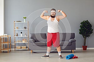 Funny fat man in red shorts and white t-shirt smiling doing exercises in the room