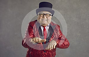 Funny fat senior man in a red sequin jacket having fun at a crazy retro disco party