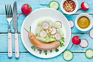 Funny food idea for kids - cute snail from sausage with vegetables