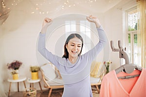 Funny foxy woman dancing with steamer iron. Housewife having fun while ironing clothes