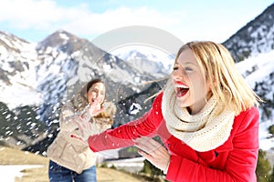 Funny friends joking throwing snowballs photo