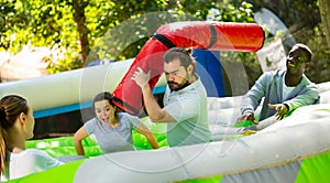 Funny friends playing on an inflatable trampoline in an amusement park