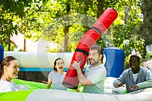 Funny friends playing on an inflatable trampoline in an amusement park