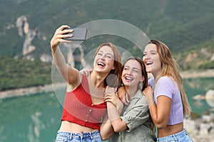 Funny friends taking selfies on smartphone in the mountain
