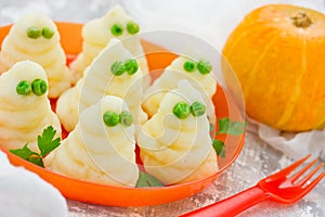 Funny ghosts from mashed potatoes and green peas, creative dinner dish for Halloween