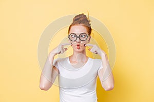 Funny ginger woman in eyeglasses puffed-off cheeks