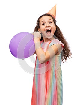 funny girl in birthday party hat blowing balloon