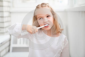 Funny girl cleans teeth electric toothbrush