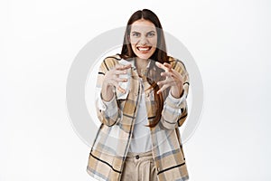 Funny girl clench hands and making weird face as if strangle someone, wants to kill or choke annoying person, standing photo