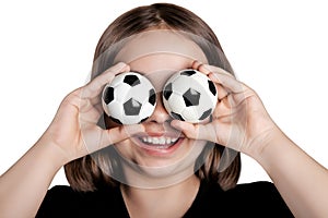 Funny girl closed her eyes with soccer balls.