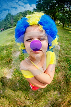Funny girl in clown wig with blue nose