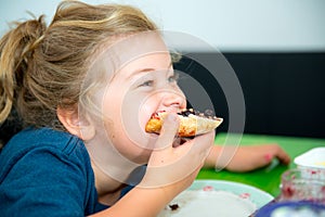 Funny girl eating bread roll with marmelade