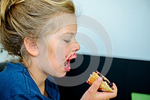 Funny girl eating bread roll with marmelade