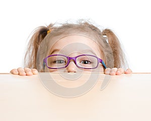 Funny girl in eyeglasses hiding behind table