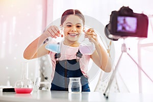 Funny girl fond of chemistry filming video while making experiment